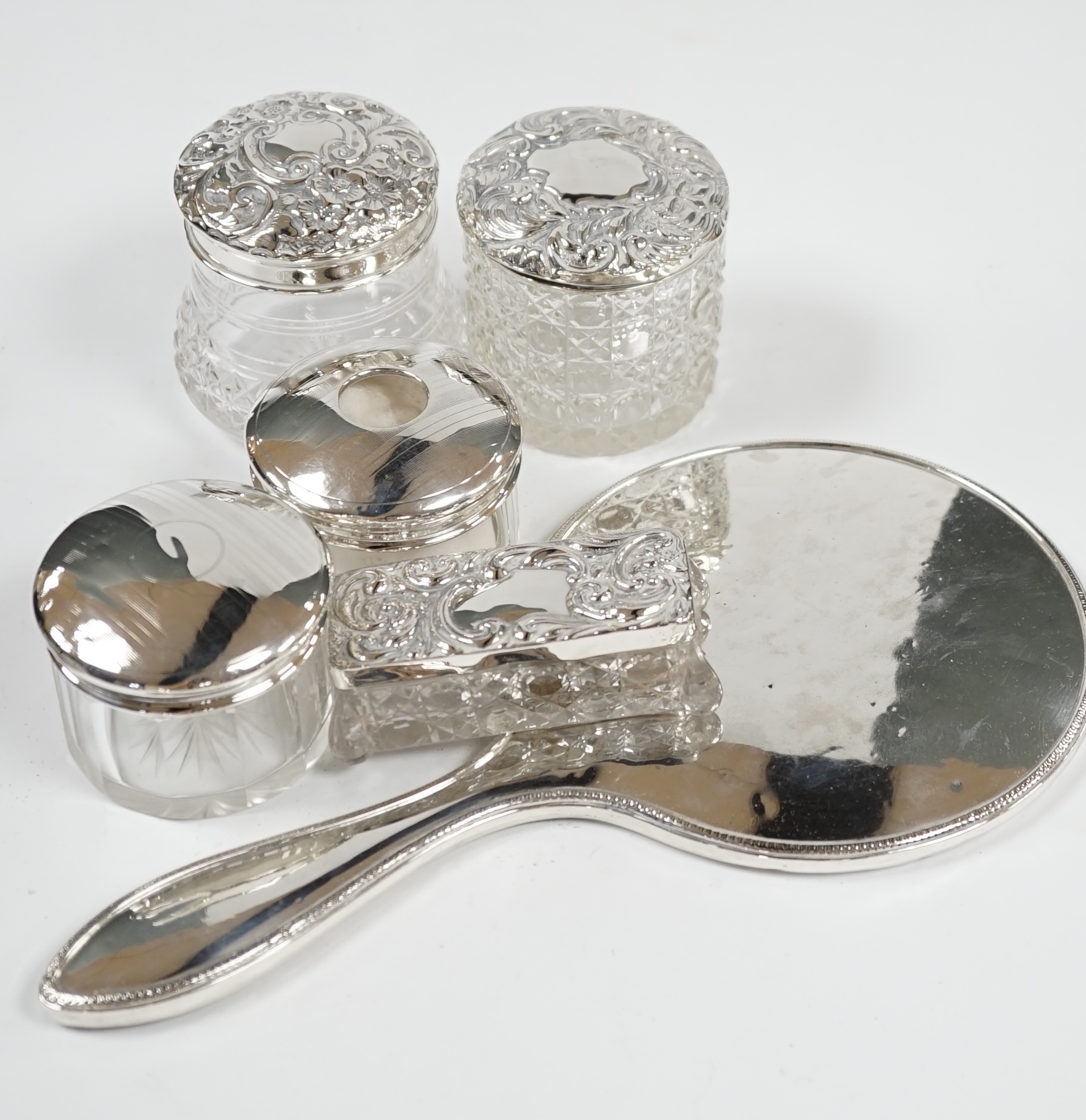 A silver hand mirror, marks rubbed and five assorted silver mounted glass toilet jars. Condition - poor to fair